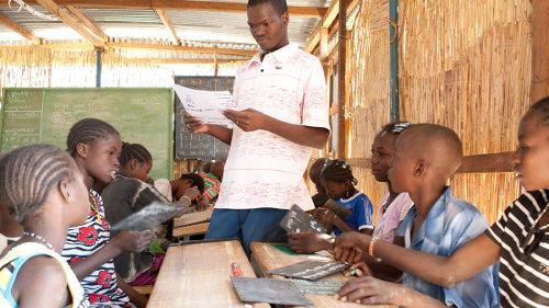 photo d'un enseignant et de ses élèves dans une salle de classe 